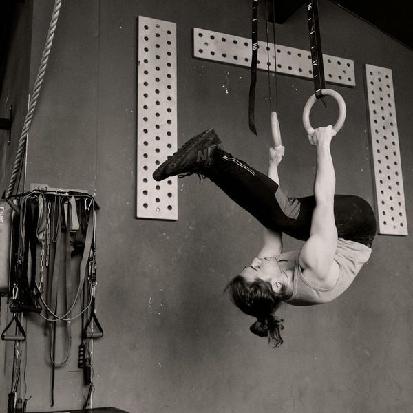 Man holding a difficult bodyweight pose, showing muscle control.